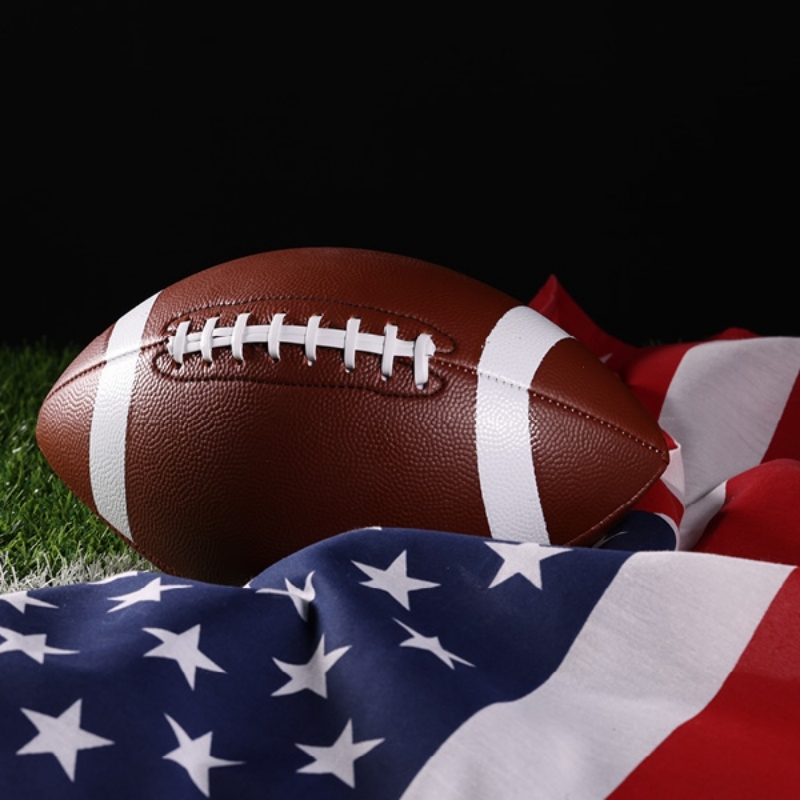 Football laying on an American flag in grass
